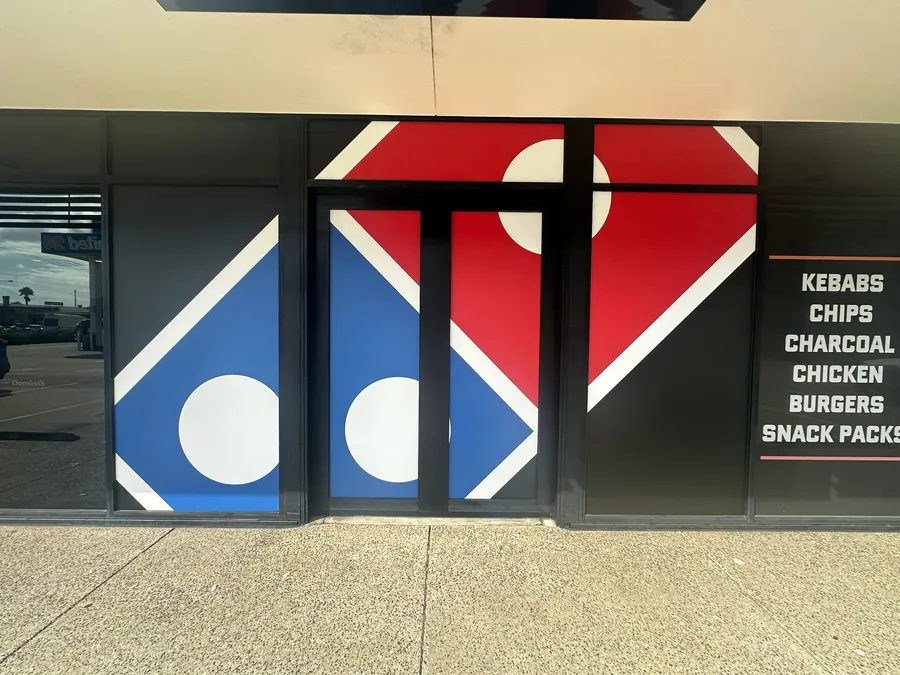 Domino's cut vinyl window graphic covering the shopfront glazing in red, blue and white